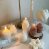 Assorted handmade Christmas candles in festive shapes including Pinecone, snowflakes, taper candle, displayed together in holiday-themed colors.