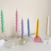 Set of colorful spiral twist soy wax taper candles in pastel green, pink, lavender, blue, yellow, and cream, displayed in clear glass holders, perfect for dinner table decor, wedding centerpieces, and modern home styling.