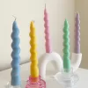 Set of colorful spiral twist soy wax taper candles in pastel green, pink, lavender, blue, yellow, and cream, displayed in clear glass holders, perfect for dinner table decor, wedding centerpieces, and modern home styling.
