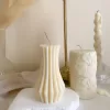 Handmade vase column aesthetic candle in ivory soy wax with a modern fluted design, displayed on a white stone base with pampas grass and other decorative candles in the background. This sculptural column candle is perfect for minimalist home décor, wedding centerpieces, or as a unique handmade gift, adding timeless elegance and modern style to any space.