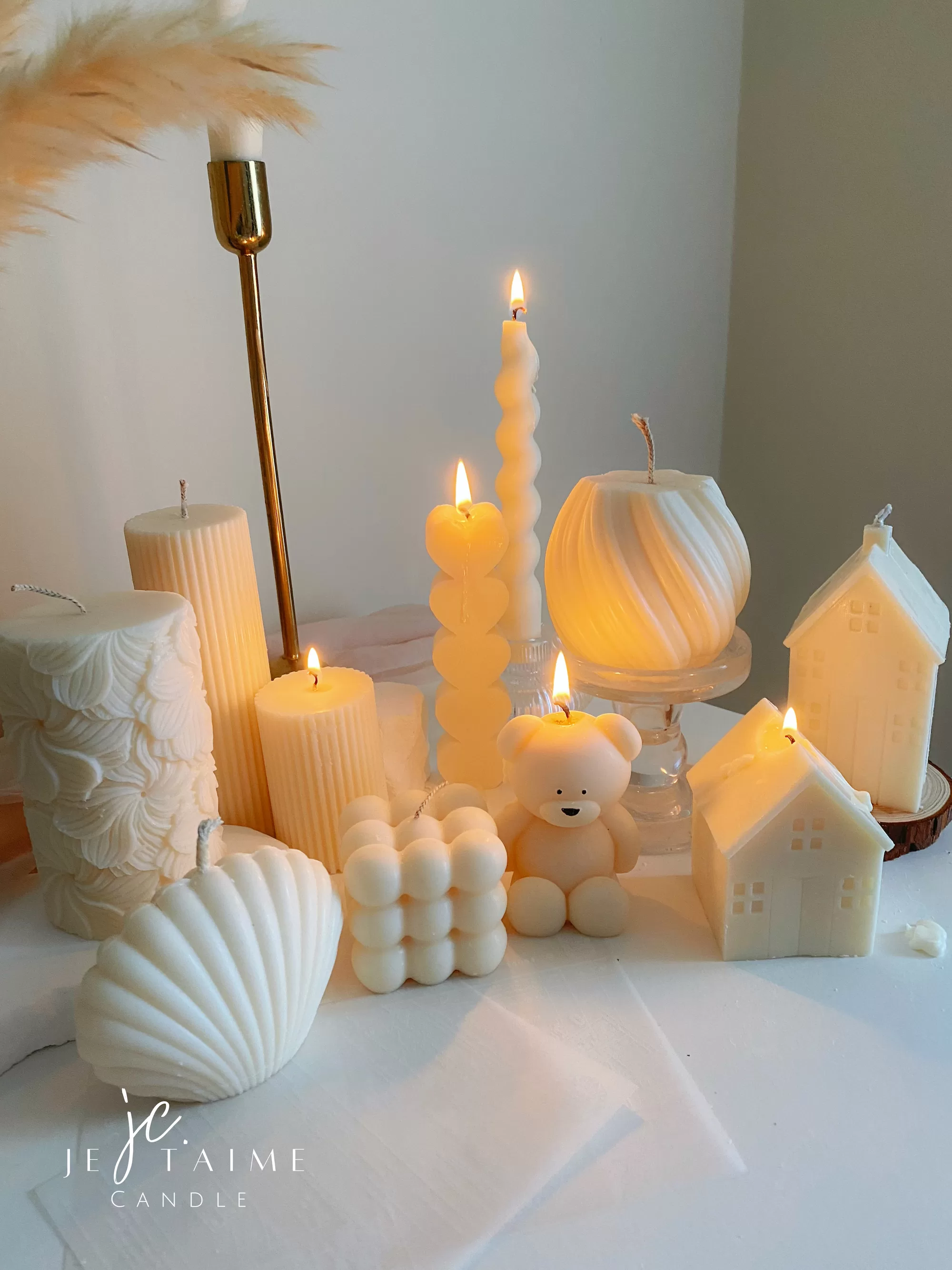 Handmade soy wax decorative candles in creamy white, including ribbed pillar, bubble cube, spiral twist, heart-shaped, bear-shaped, and swirl ball designs, lit for cozy aesthetic home décor, wedding table decoration, or unique gift ideas.