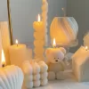 Handmade soy wax decorative candles in creamy white, including ribbed pillar, bubble cube, spiral twist, heart-shaped, bear-shaped, and swirl ball designs, lit for cozy aesthetic home décor, wedding table decoration, or unique gift ideas.