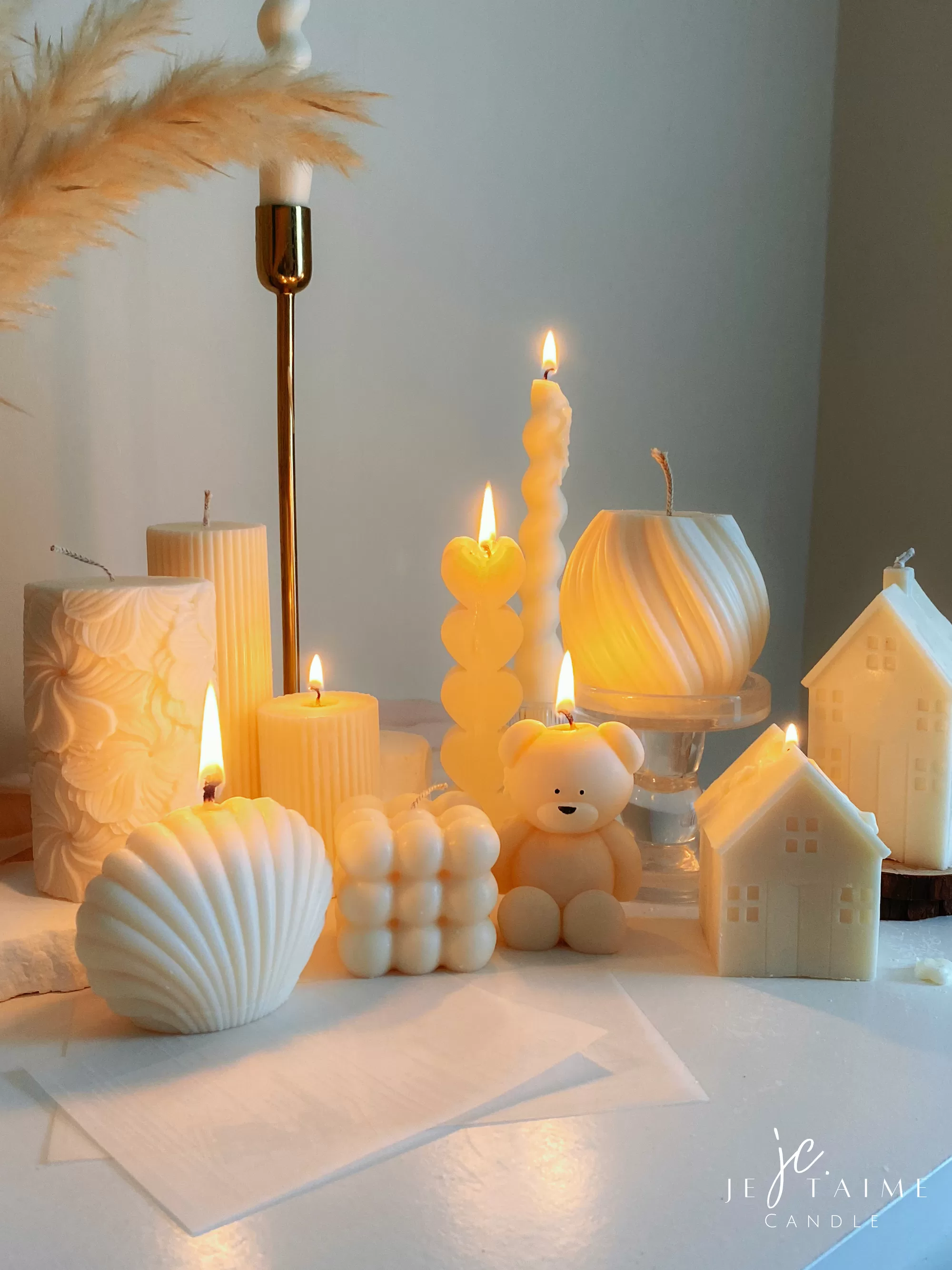 Handmade soy wax decorative candles in creamy white, including ribbed pillar, bubble cube, spiral twist, heart-shaped, bear-shaped, and swirl ball designs, lit for cozy aesthetic home décor, wedding table decoration, or unique gift ideas.