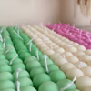 A collection of colorful candles labeled with personalized tags, alongside mini baby bubble candles for special events.